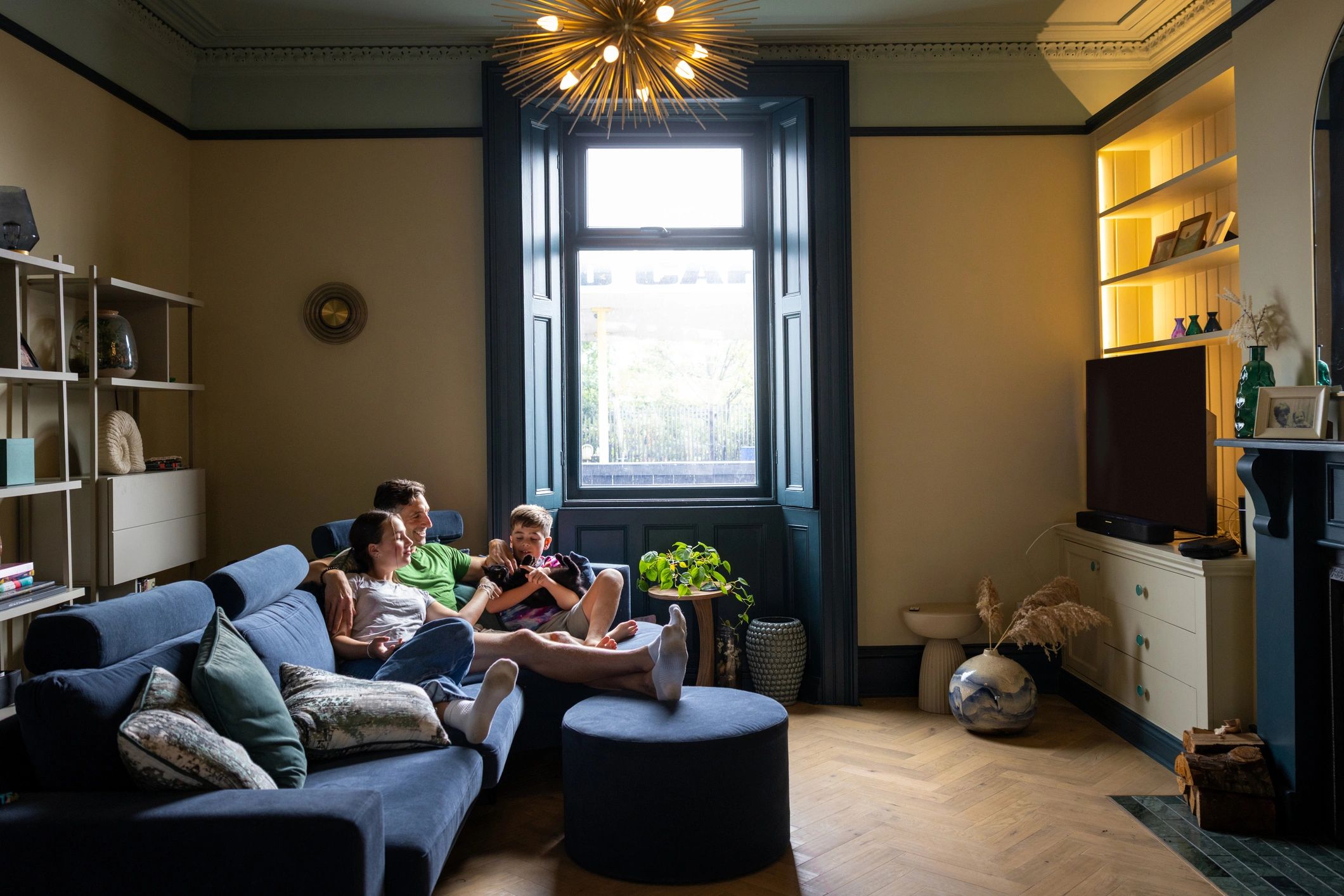 Family relaxing on a sofa watching TV in a cozy living room